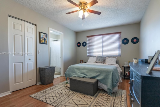 bedroom featuring a textured ceiling, light hardwood / wood-style flooring, a closet, and ceiling fan