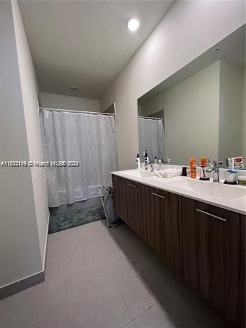 bathroom with tile patterned flooring and dual bowl vanity