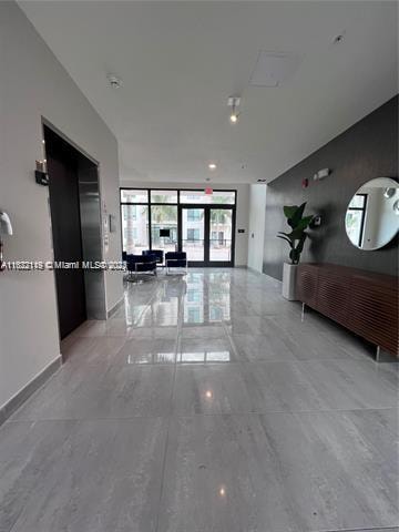 hall featuring light tile patterned flooring and expansive windows