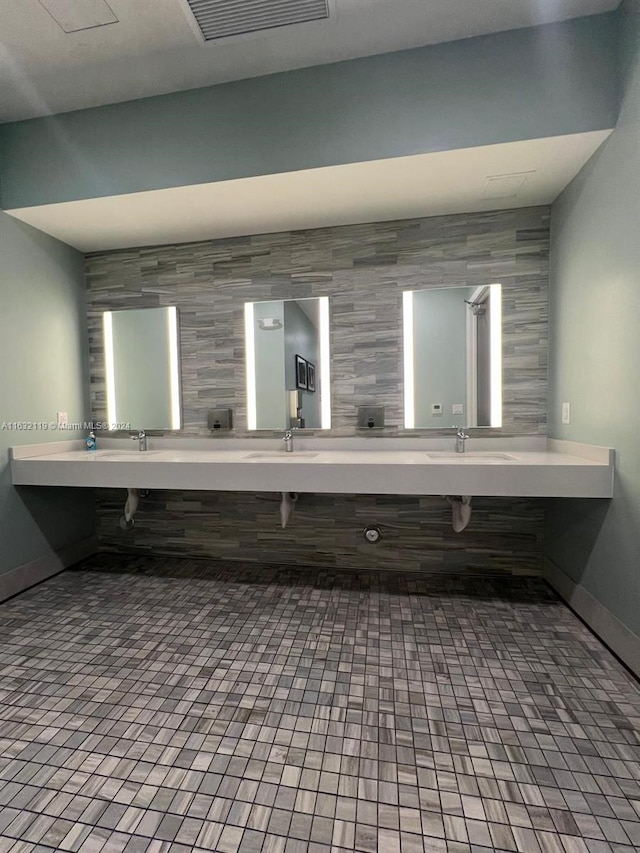 bathroom with double vanity, tile walls, and tile patterned floors