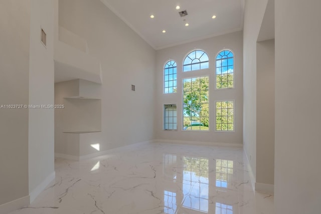 unfurnished room featuring a high ceiling and ornamental molding