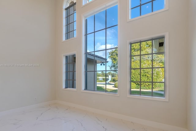 empty room with plenty of natural light and a towering ceiling