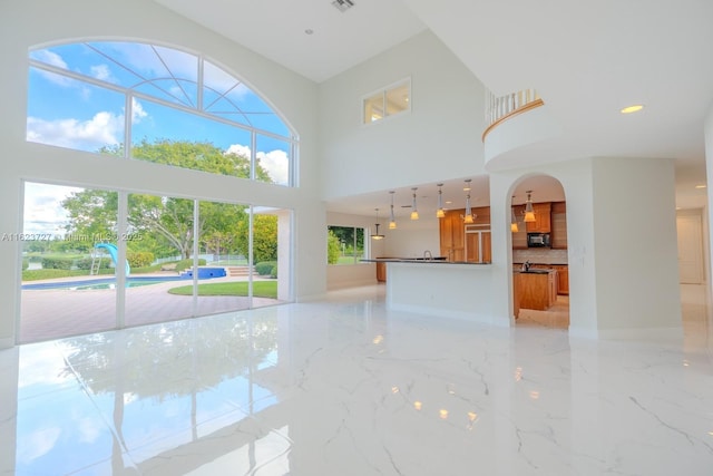 unfurnished living room featuring a high ceiling