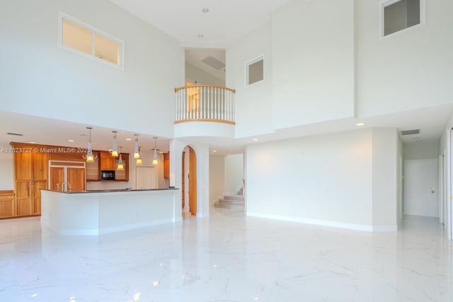 unfurnished living room with a towering ceiling