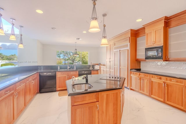 kitchen with tasteful backsplash, sink, black appliances, hanging light fixtures, and an island with sink