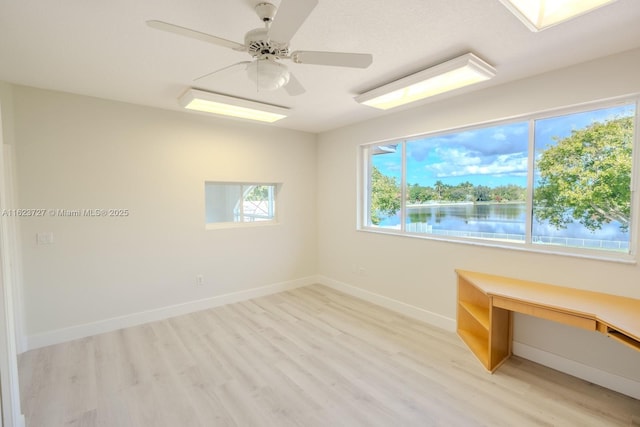 unfurnished room featuring ceiling fan, light hardwood / wood-style flooring, and a healthy amount of sunlight