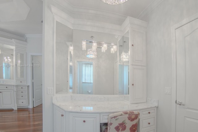 bathroom featuring vanity, wood-type flooring, and ornamental molding