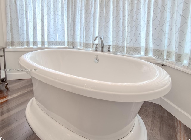 bathroom with a bath and hardwood / wood-style floors