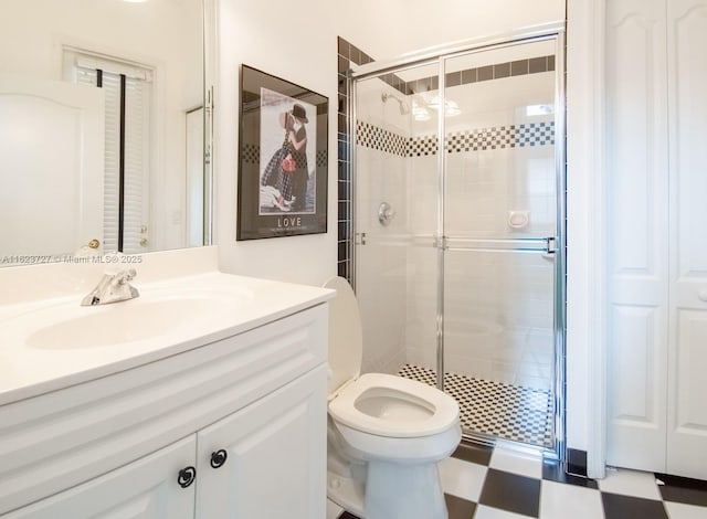 bathroom featuring vanity, toilet, and a shower with door