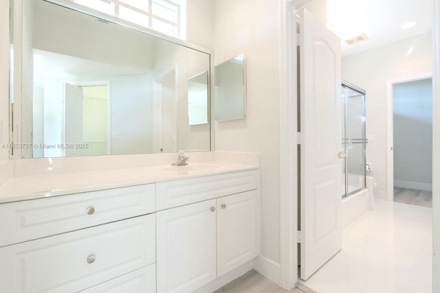 bathroom with vanity and combined bath / shower with glass door