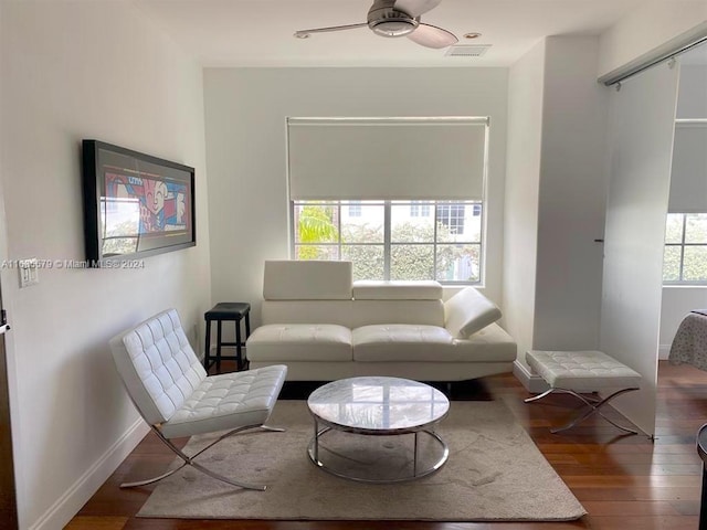 sitting room with a healthy amount of sunlight, wood-type flooring, and ceiling fan