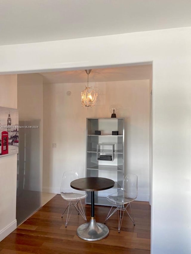 dining area featuring wood-type flooring and a notable chandelier