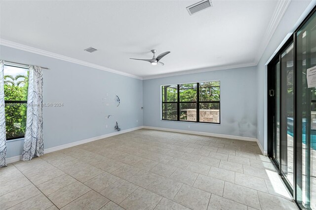 tiled spare room featuring ornamental molding and ceiling fan