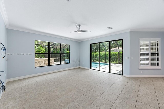 unfurnished room with light tile patterned floors, crown molding, and a wealth of natural light