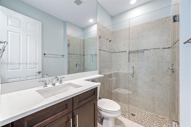 bathroom with tile patterned floors, vanity, an enclosed shower, and toilet