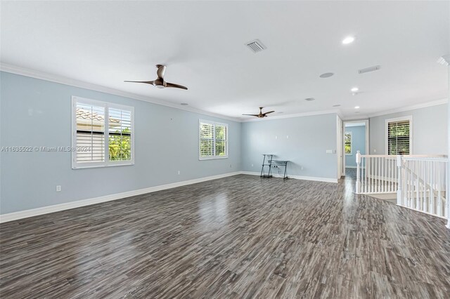 unfurnished living room featuring ornamental molding, ceiling fan, and dark wood-type flooring