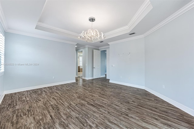 unfurnished room featuring dark hardwood / wood-style floors, a raised ceiling, and ornamental molding