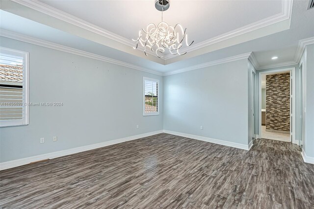 unfurnished room featuring a notable chandelier, crown molding, hardwood / wood-style floors, and a tray ceiling