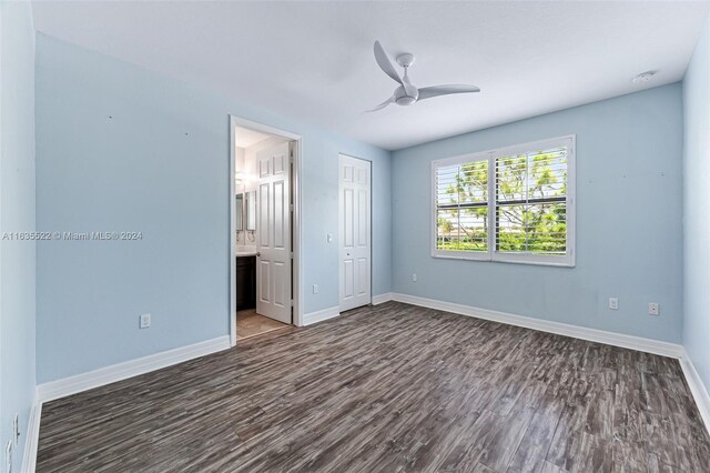 unfurnished bedroom featuring ceiling fan, a closet, hardwood / wood-style floors, and ensuite bathroom