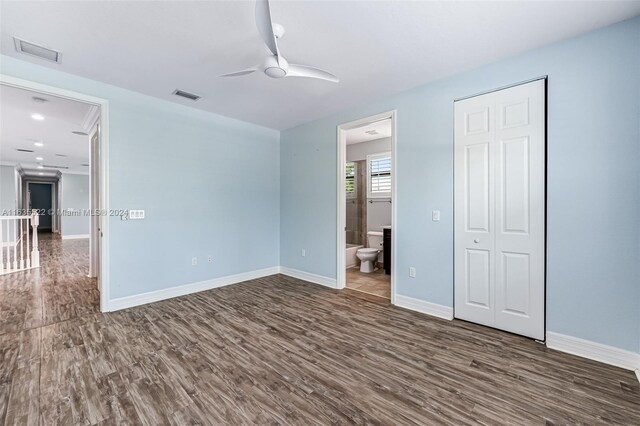 unfurnished bedroom featuring ensuite bath, ceiling fan, and hardwood / wood-style floors