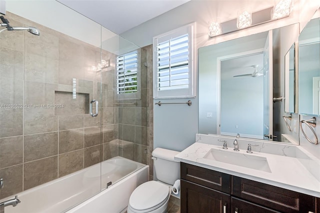 full bathroom featuring vanity, toilet, ceiling fan, and bath / shower combo with glass door