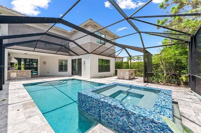 view of pool featuring a patio area, an in ground hot tub, and glass enclosure