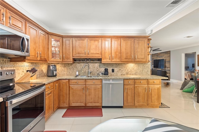 kitchen with light tile patterned floors, light stone countertops, appliances with stainless steel finishes, decorative backsplash, and sink