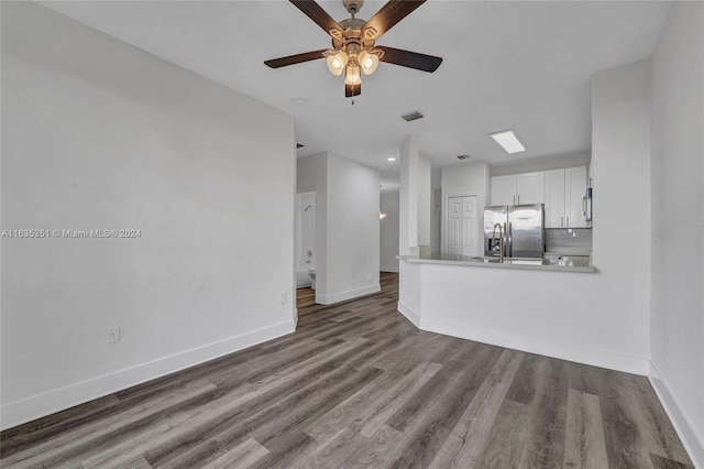 unfurnished living room with ceiling fan and hardwood / wood-style flooring