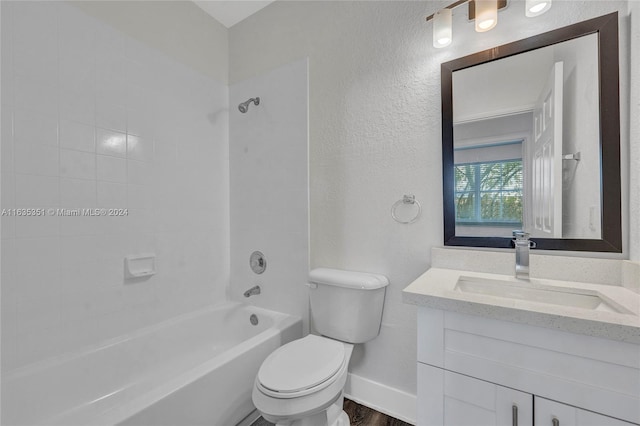 full bathroom with hardwood / wood-style floors, vanity, tiled shower / bath combo, and toilet