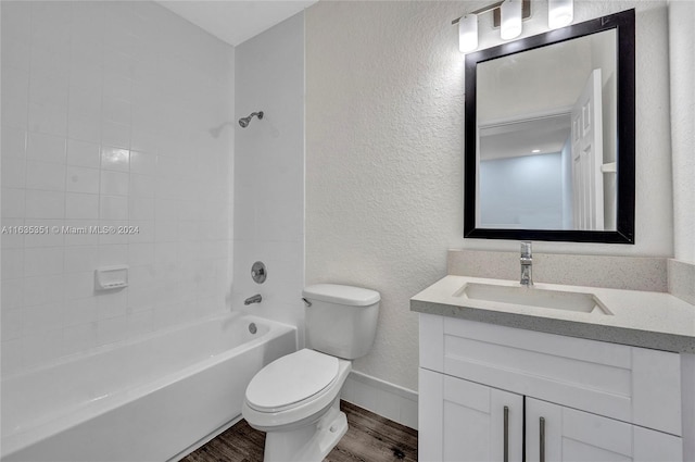 full bathroom featuring tiled shower / bath combo, hardwood / wood-style floors, vanity, and toilet