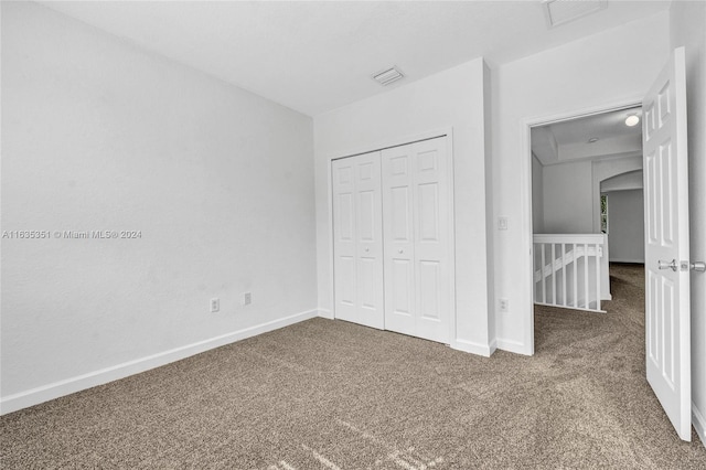 unfurnished bedroom with carpet and a closet