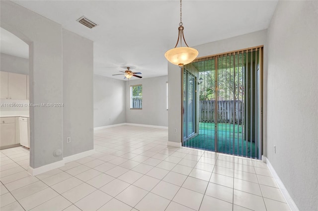 unfurnished room with ceiling fan, a wealth of natural light, and light tile patterned floors