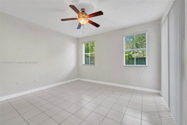 tiled spare room featuring ceiling fan