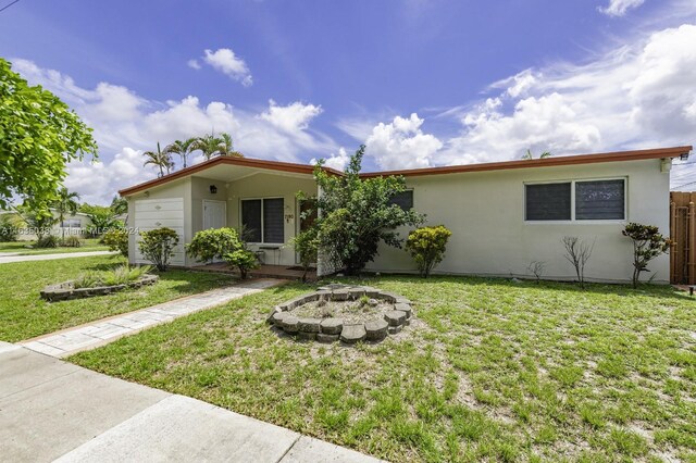 single story home with a front lawn and an outdoor fire pit