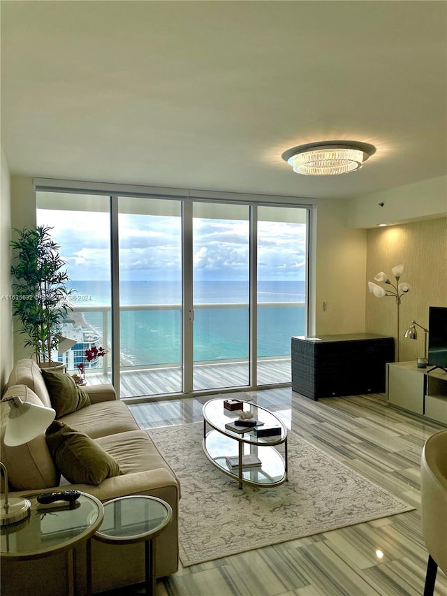 living room featuring floor to ceiling windows, a water view, and light hardwood / wood-style flooring