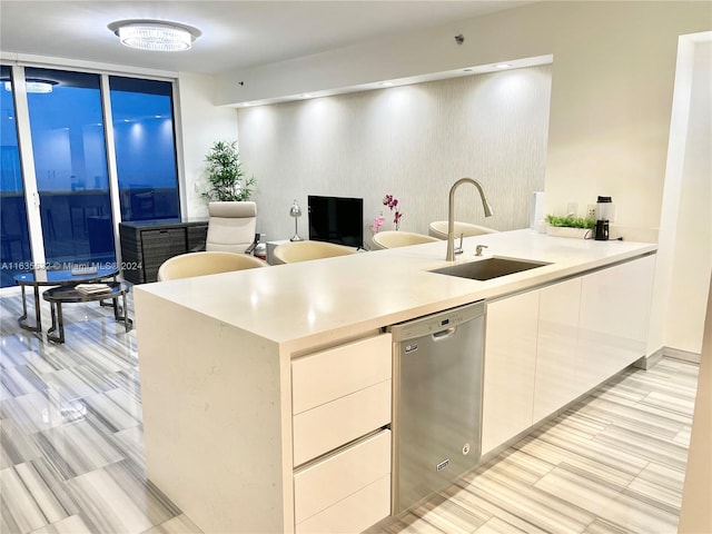 kitchen with sink, light tile patterned flooring, dishwasher, and kitchen peninsula