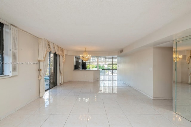 unfurnished room with light tile patterned floors, visible vents, baseboards, and an inviting chandelier