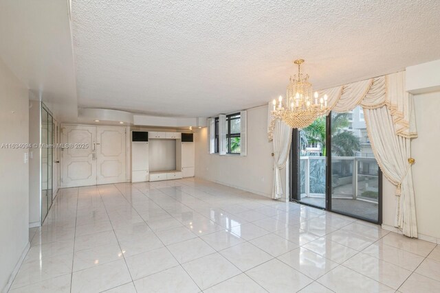 unfurnished room featuring a chandelier, a textured ceiling, and light tile patterned floors