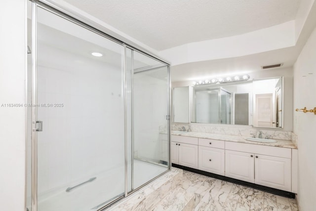 bathroom featuring visible vents, double vanity, a sink, a shower stall, and marble finish floor