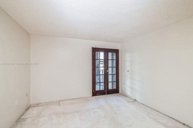 empty room with french doors, carpet floors, and a textured ceiling