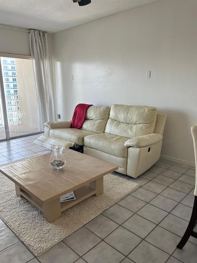 living room with a textured ceiling and light tile patterned floors