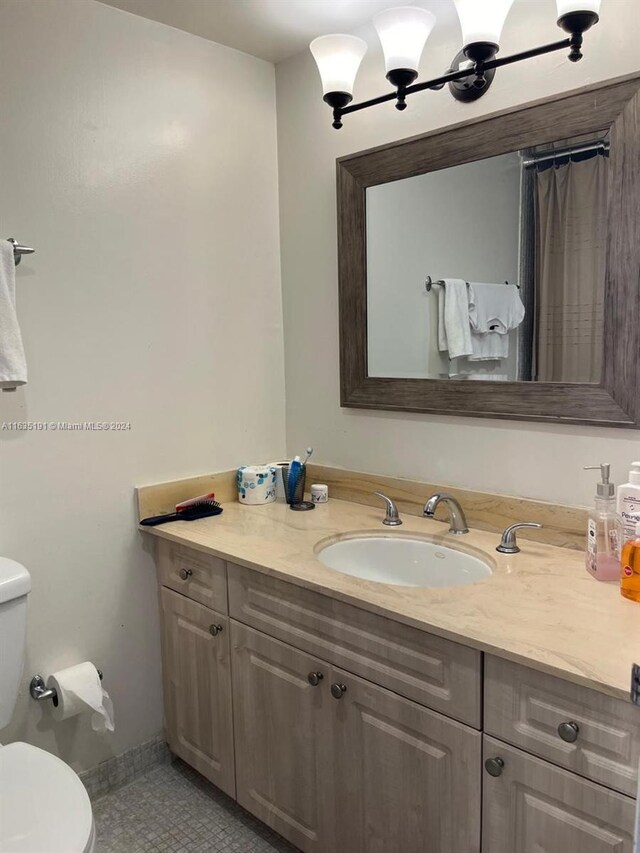 bathroom with tile patterned flooring, vanity, and toilet