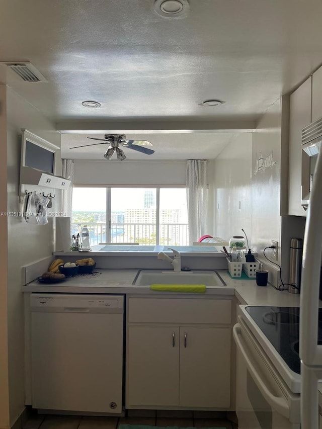 kitchen with a sink, white cabinetry, visible vents, and dishwasher