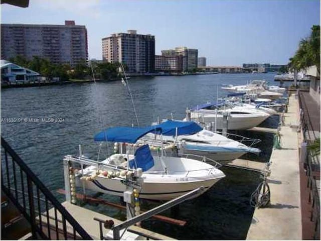 view of dock with a water view, a city view, and boat lift