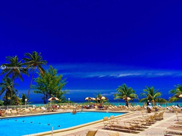 view of pool at twilight