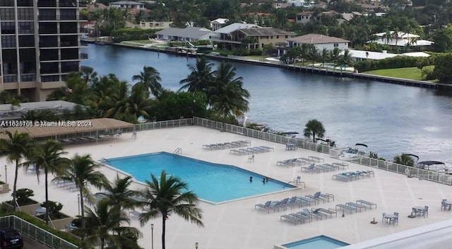 view of swimming pool featuring a patio and a water view