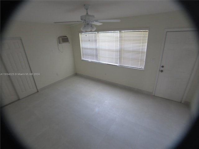 empty room with ceiling fan and a wall unit AC