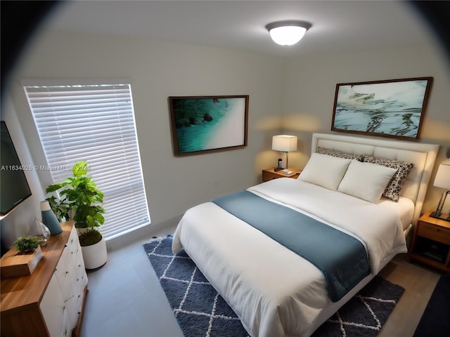 bedroom featuring multiple windows and dark hardwood / wood-style floors