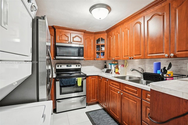 kitchen with light tile patterned floors, appliances with stainless steel finishes, backsplash, and sink