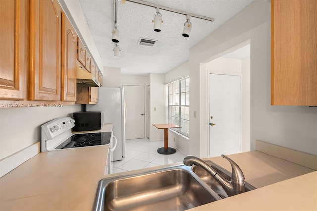 kitchen with white electric range, sink, a textured ceiling, light tile patterned floors, and track lighting